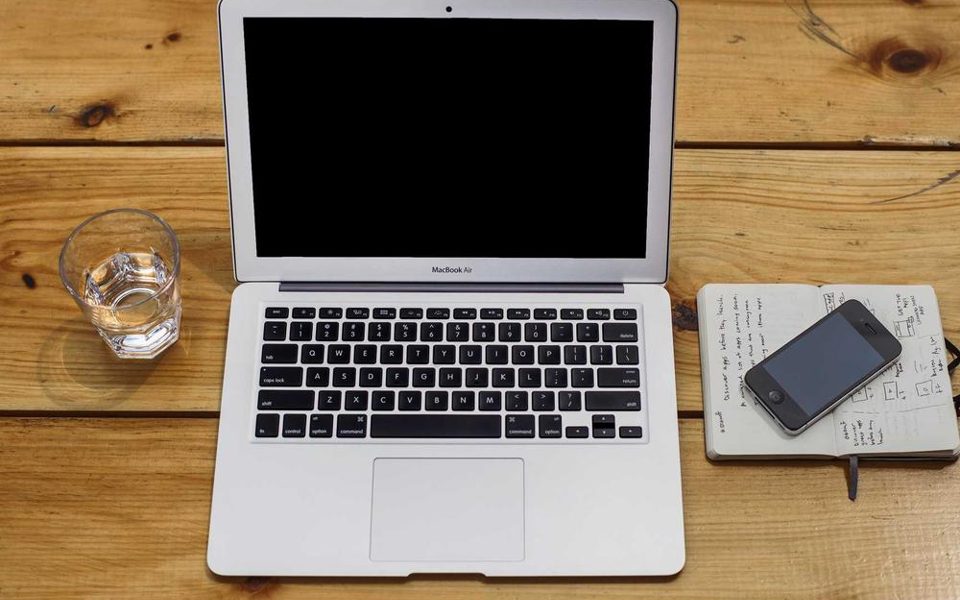 En laptop og en notatbok sett ovenfra